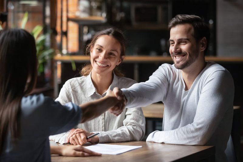 couple shaking local insurance agents hand