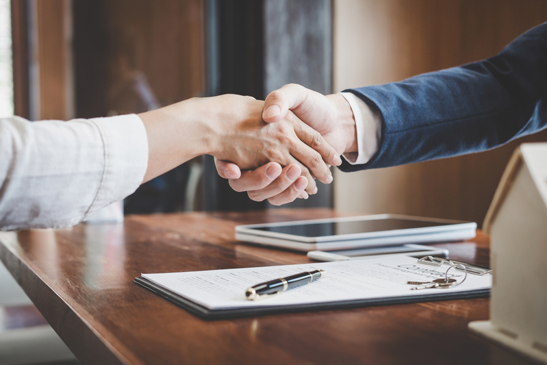 handshake over paperwork